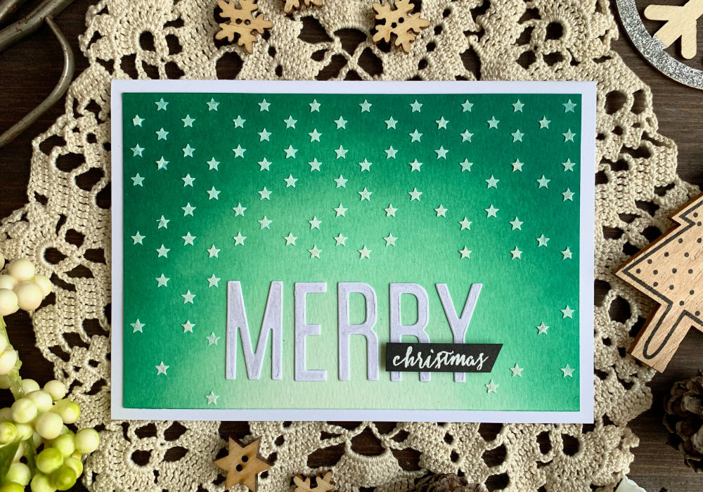 Make a handmade Christmas card with a teal Distress ink background using the inks Pine Needles, Lucky Clover and Cracked Pistachio. Covered with stars made using a stencil and embossing paste.