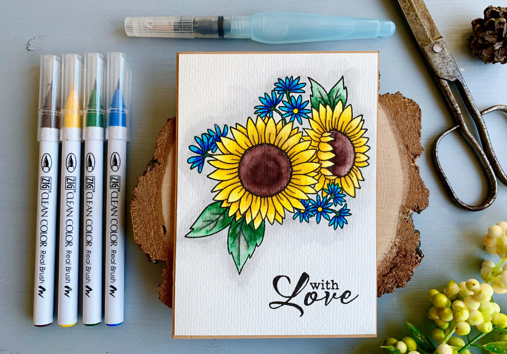 Handmade card for Mother's Day with a stamped sunflowers and coloured with water based markers. The sunflower is yellow with brown center and green leaves and tiny flowers coloured with blue markers. 