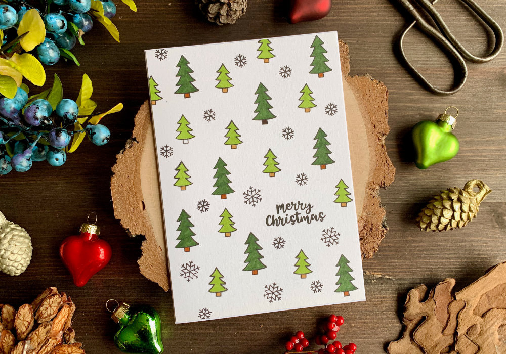 Quick and easy handmade Christmas card with a simple stamped background using stamps with snowflakes and trees and colouring them with green alcohol markers. 