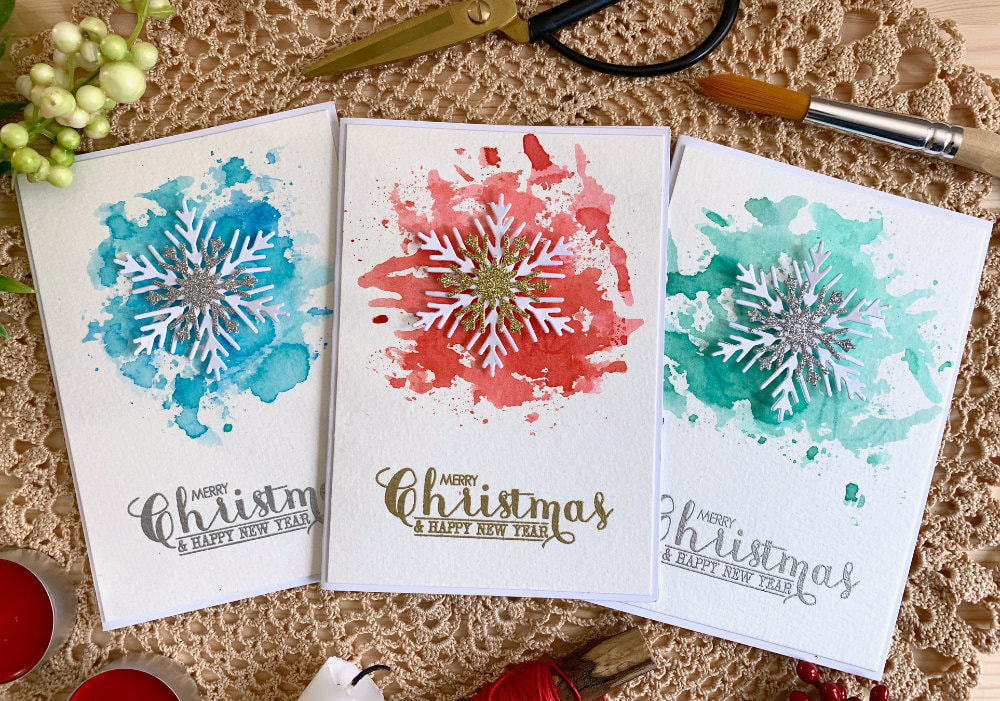Handmade DIY Christmas card using a sparkly snowflake die cuts and creating a background using the Distress ink watercolour smooshing technique. The Distress ink smooshing technique is great to create a background where you can control where the colours are applied. 