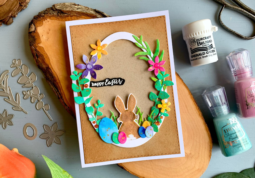 Handmade Easter card with a wreath in a shape of an egg, with a stamped bunny and die-cut leaves, flowers and Easter eggs.