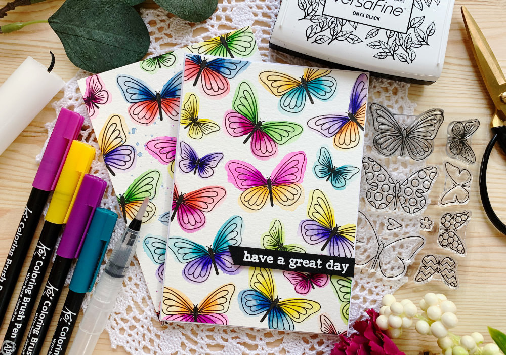 A colourful butterfly card featuring a simple stamped background using individual stamps and messy watercolour technique using water based brush markers. 