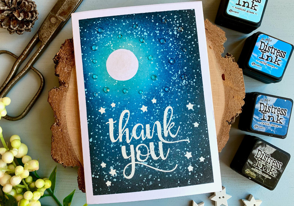 Make a Thank You card by creating a night sky background with a moon and stars using Distress inks - Black Soot, Faded Jeans, Salty Ocean and Tumbled Glass and stamping and heat embossing in white a big Thank You sentiment.