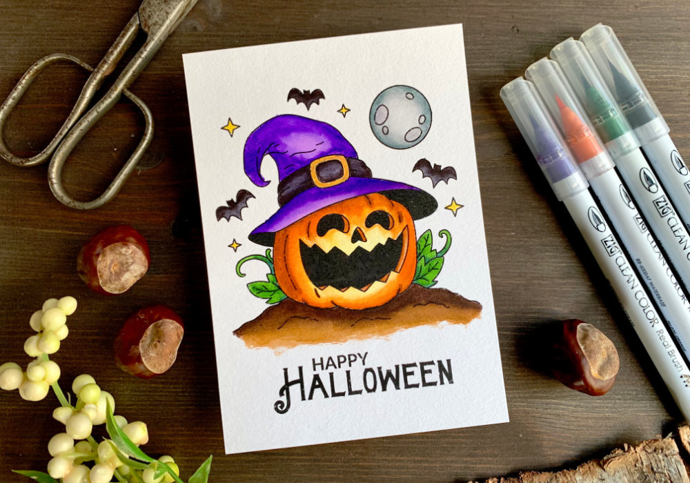Handmade Halloween greeting card and/or picture for to put into a frame with a pumpkin wearing a hat of a witch, coloured with waterbased markers.