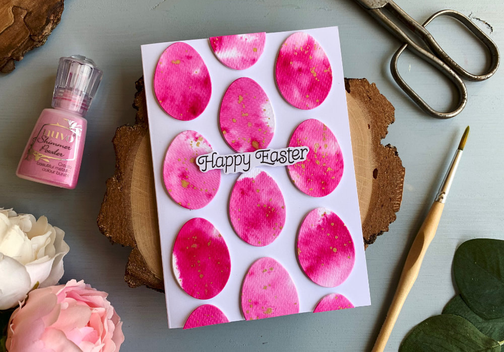 Make a very simple Easter card by creating a watercolour faux tie-dye background using Nuvo Shimmer Powders, die-cut multiple eggs and adhere them on top of a card base. 
