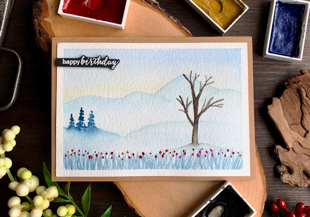 Budget friendly, handmade Happy Birthday card with a watercolour winter landscape, perfect for beginners. 