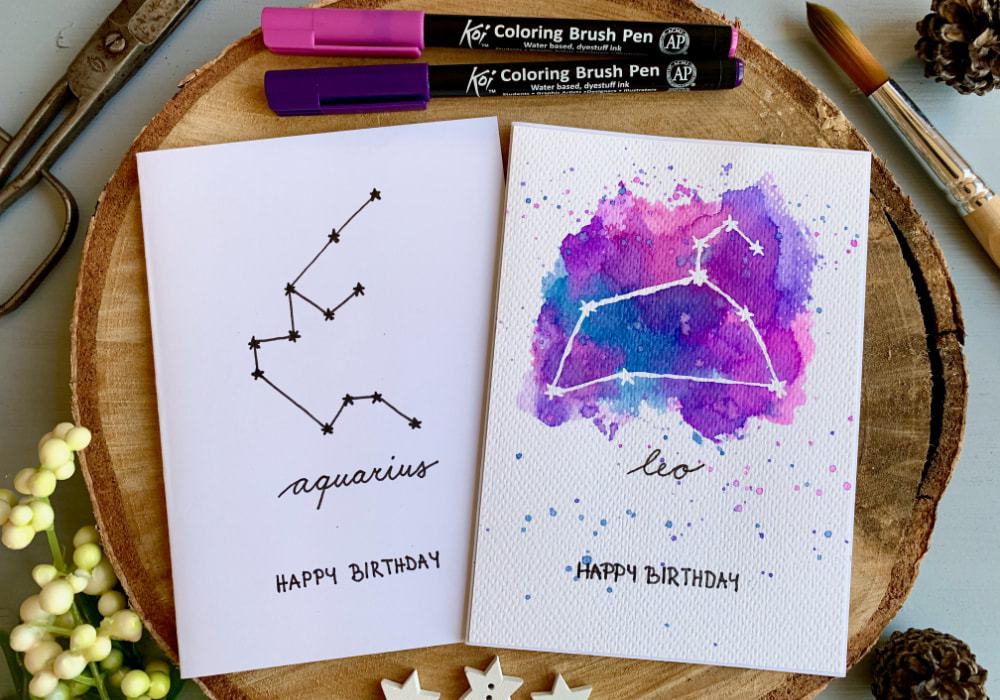 Handmade cards with the Zodiac star signs - Aquarius and Leo. One card is minimal using a black fine liner and the other has pop of colour created by doing the ink smooshing technique with water-based markers.