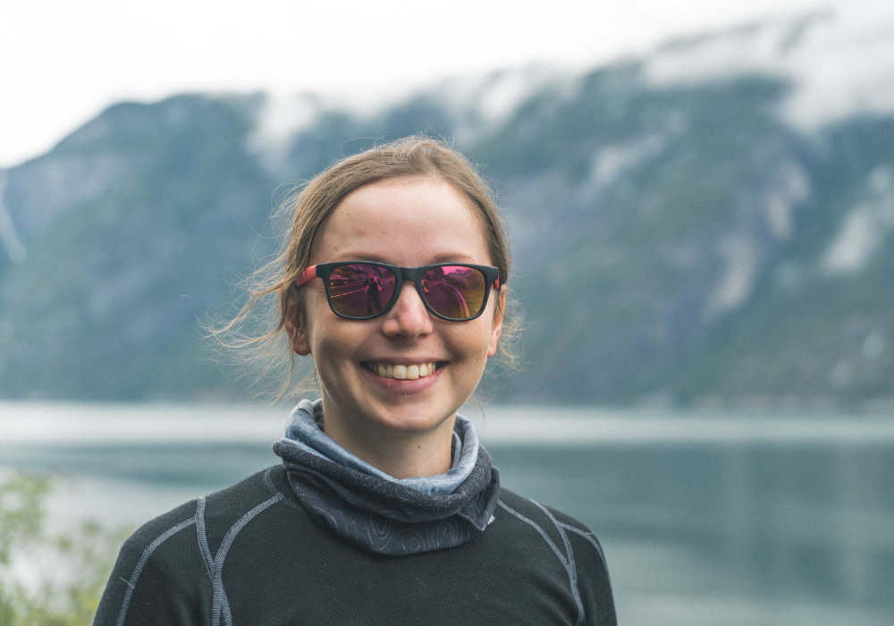 Photo of me wearing sunglasses and smiling at the bottom of a fjord near the town Eidfjord in Norway.