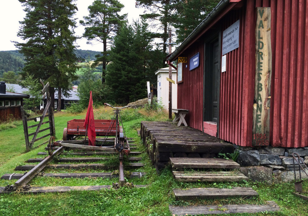 Old train station with a red wooden building in the Valdres Folk Museum.
