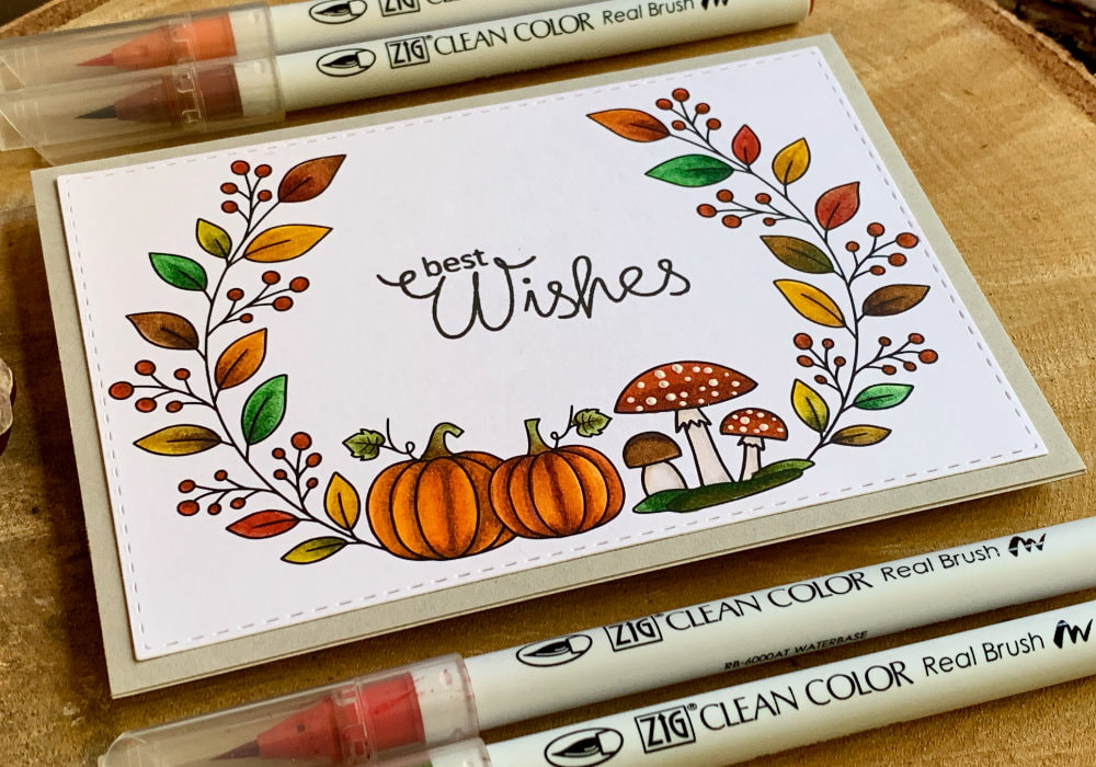 Handmade autumnal Birthday greeting card with a wreath with pumpkins and red mushrooms, leaves and berries on each side, coloured in autumnal colours using the Zig Brush Markers.