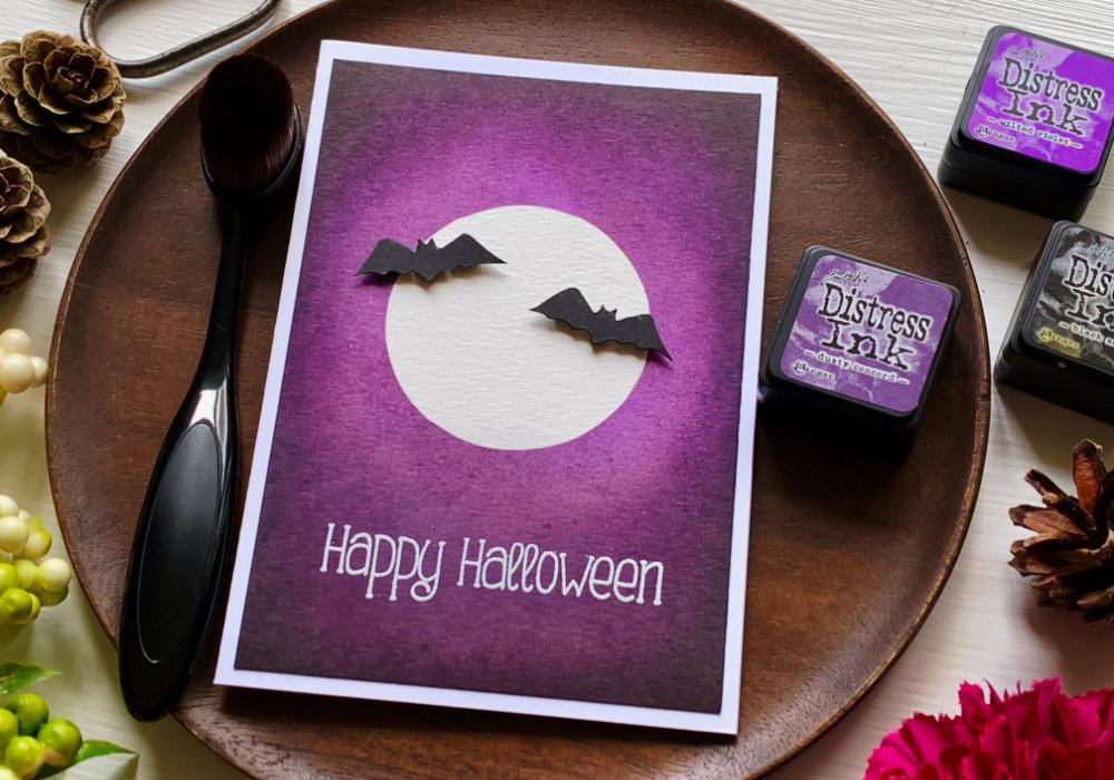 Create a very simple card for Halloween, using a mask to create a moon with bats and ink blending the background using Distress inks - Black Soot, Dusty Concord and Wilted Violet.