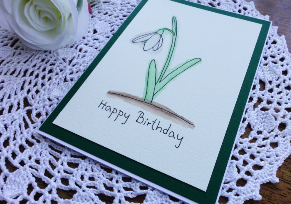 Simple spring card with the flower snowdrop, coloured with watercolour pencils.