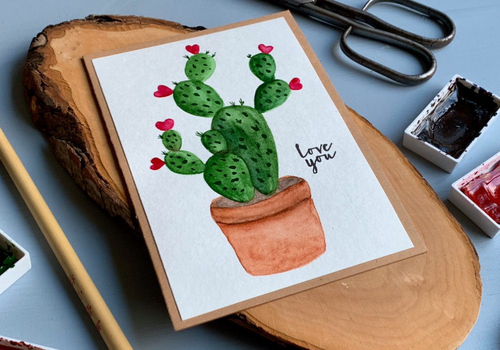 Handmade Valentine's day and anniversary greeting card with hand painted cactus and pink hearts instead of flowers. The greeting is stamped and says Love You.