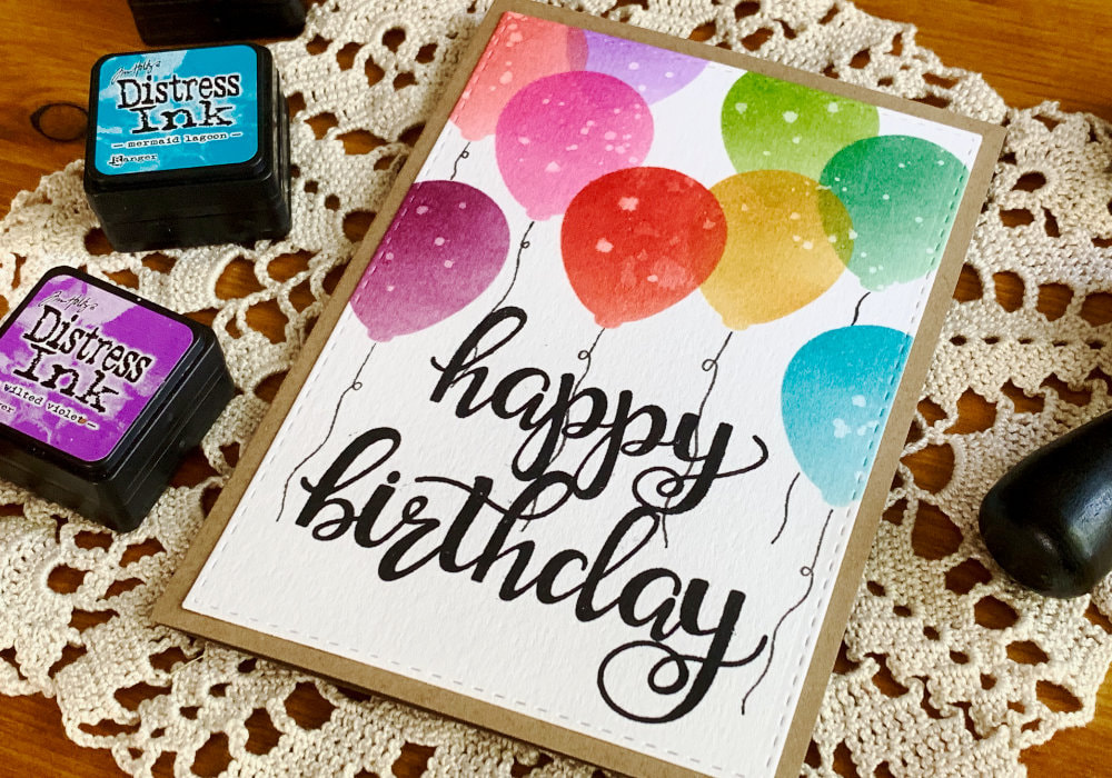Handmade Birthday card with a big black Happy Birthday greeting and balloons in various colours above it.