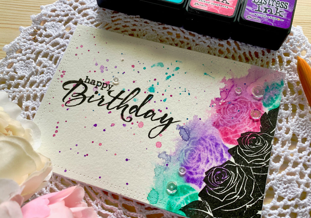 Handmade Happy Birthday card using solid stamps with roses and stamping with black inks and distress inks and reactivating the distress inks to create a messy watercolour look.