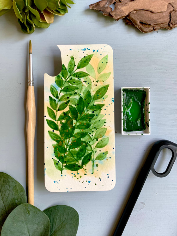 An insert that you can place into a clear mobile phone case with a background with overlapping leaves painted with watercolours in one shade of green. 