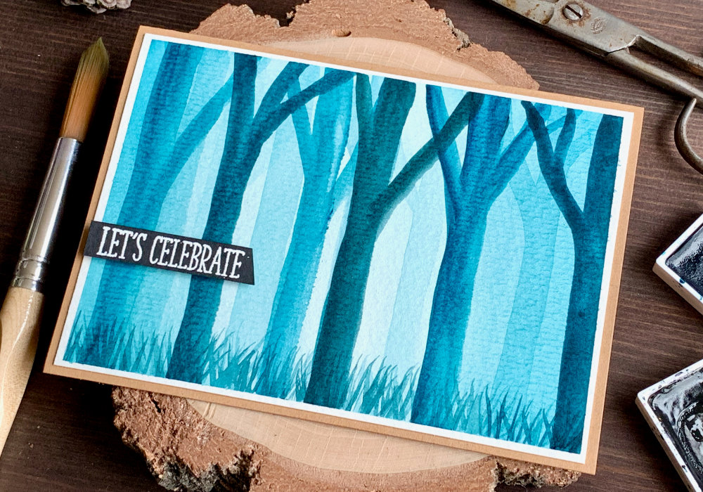 Handmade card with a misty forest painted with turquoise watercolour paint.