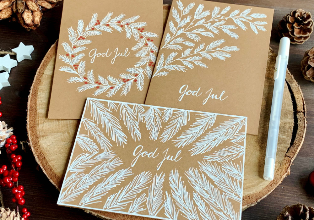 Handmade Christmas greeting cards with hand-drawn fir tree branches using only a white gel pen and a blank card.