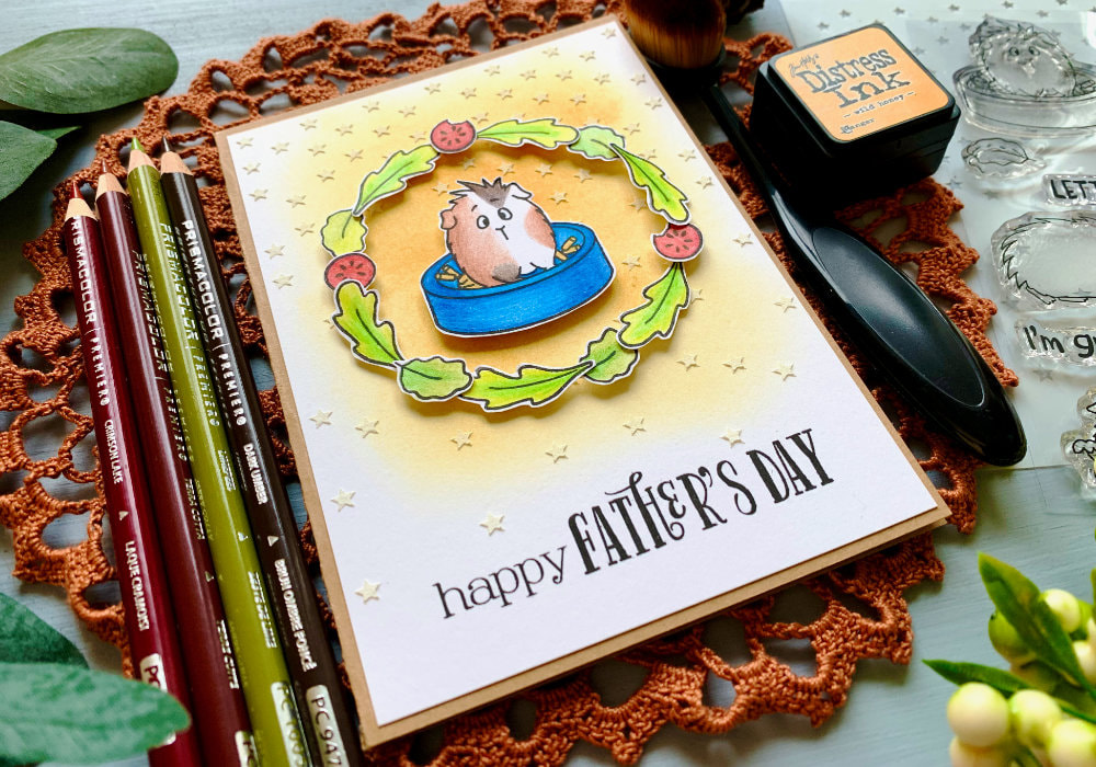 Fun masculine card for Father's Day, creating a wreath with tiny leaf and tomato stamps and guinea pig in the middle, with a yellow background covered with stars created with a stencil and embossing paste.