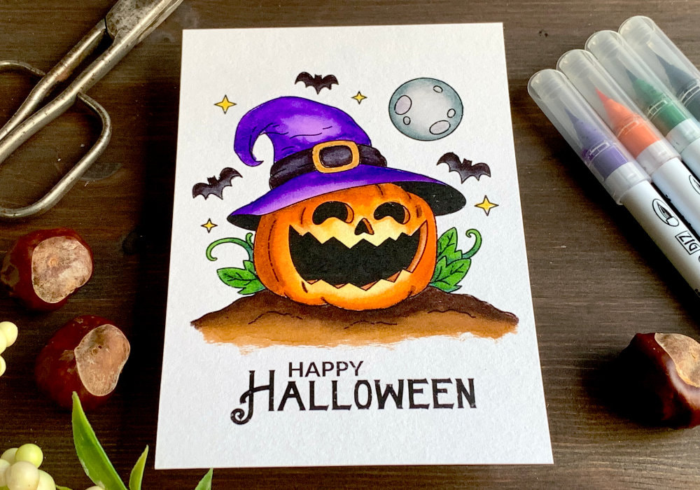 Handmade Halloween greeting card and/or picture for to put into a frame with a pumpkin wearing a hat of a witch, coloured with waterbased markers. 