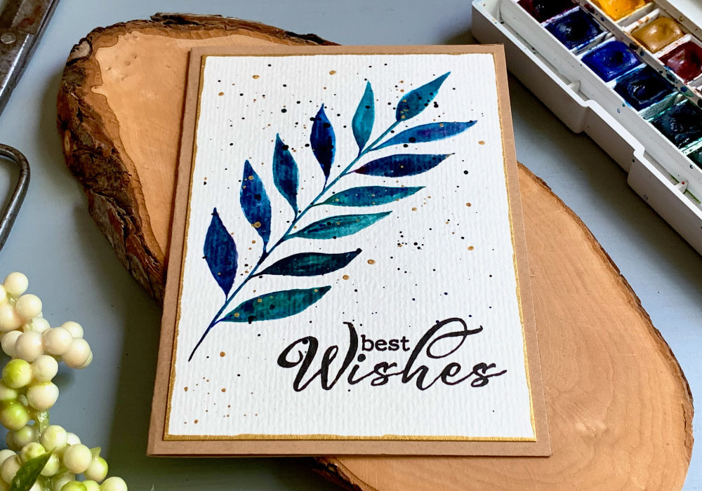 Simple handmade card with a brunch with leaves painted with watercolours in shades of blue and green and mixed with little bit of black and purple. And stamped greeting saying Best Wishes.