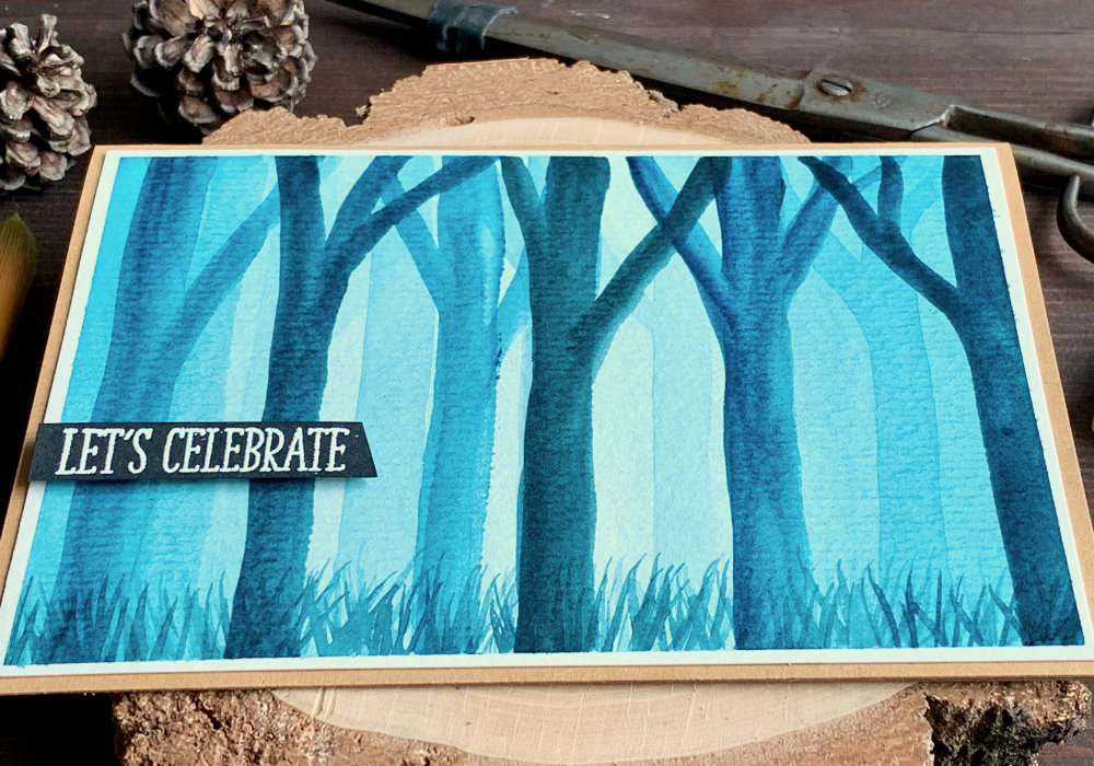Handmade card with a misty forest painted with turquoise watercolour paint.