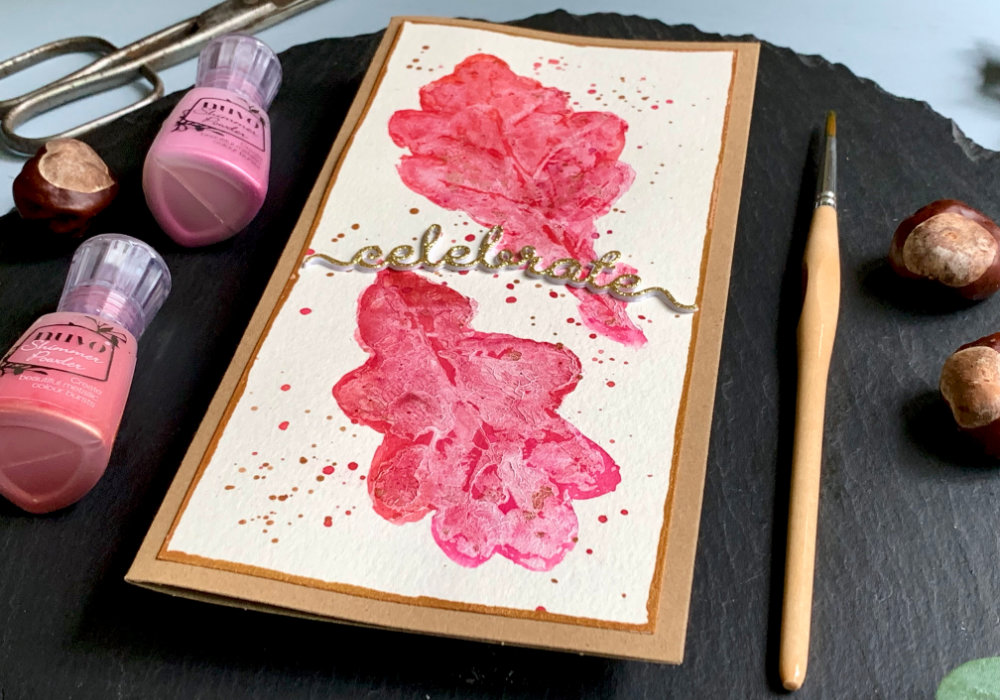 Handmade Birthday card with leaf impressions stamped by using real leaves, acrylic paint and watercolour powders from Nuvo. The greeting says Celebrate and is die cut from a golden glitter card stock.