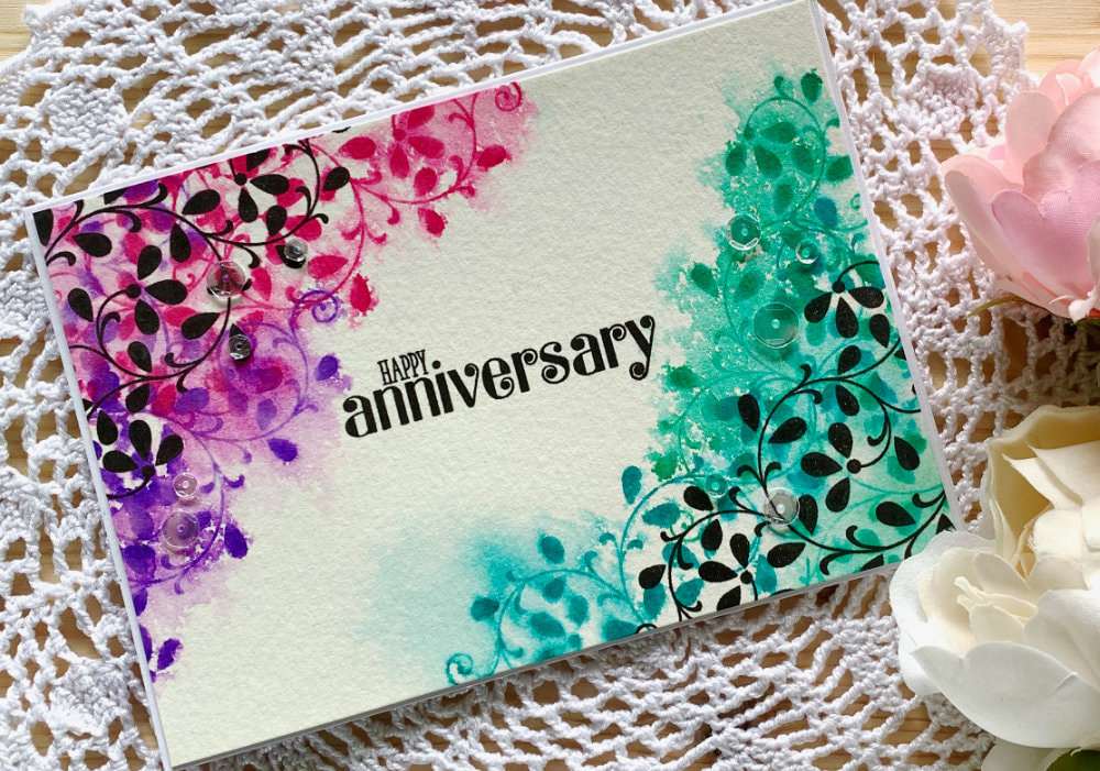 Handmade card for Aniversary using solid stamps with leafs and stamping with black inks and distress inks and reactivating the distress inks to create a messy watercolour look.