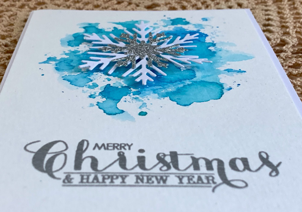  Handmade DIY Christmas card using a sparkly snowflake die cuts and creating a background using the Distress ink watercolour smooshing technique.