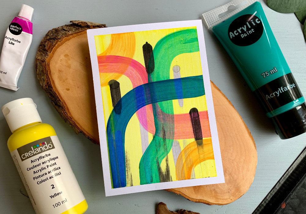 Handmade card with a background created doing the squeegee painting technique. With pink, blue and green squigely lines, few black lines and yellow background.