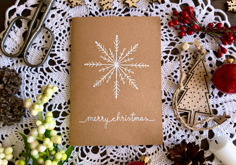 Hand drawn Christmas card with a snowflake, drawn on a craft card base with a gel pen.