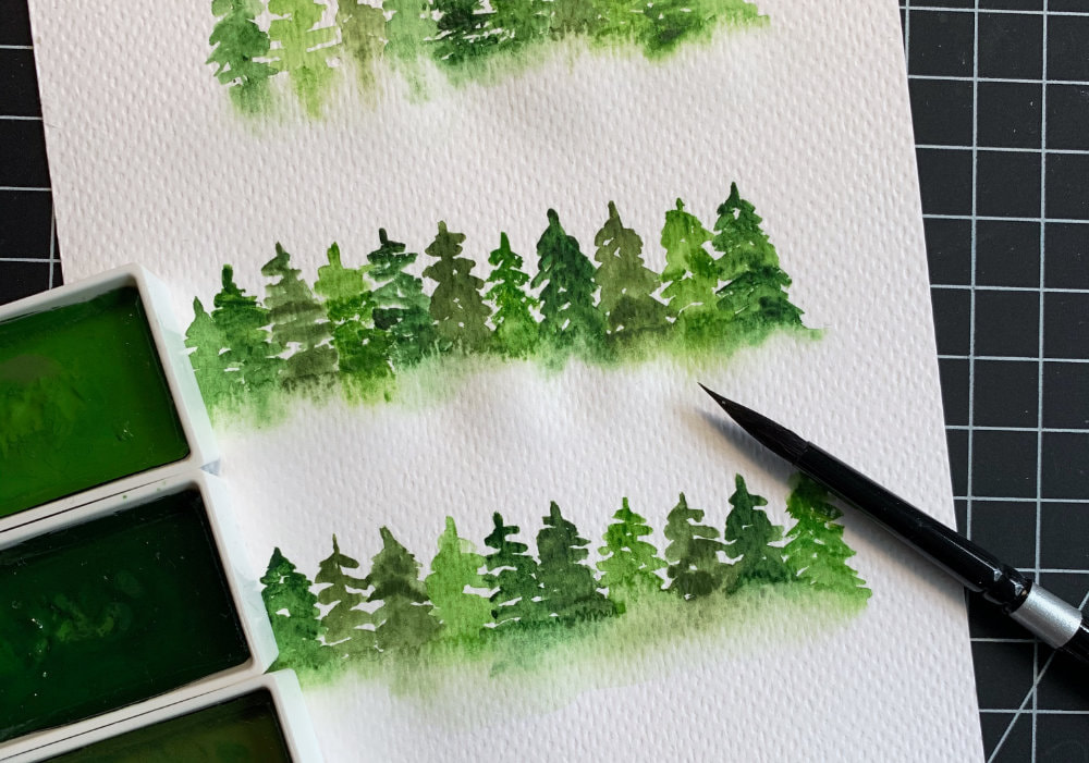 Learn how to paint a simple misty loose watercolour tree line and make easy Christmas cards. Watercolouring simple pine trees.