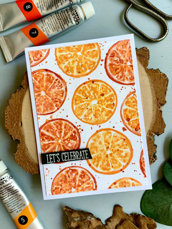 Handmade Birthday card with a background of citrus orange slices painted using watercolours and a greeting saying Let's celebrate.