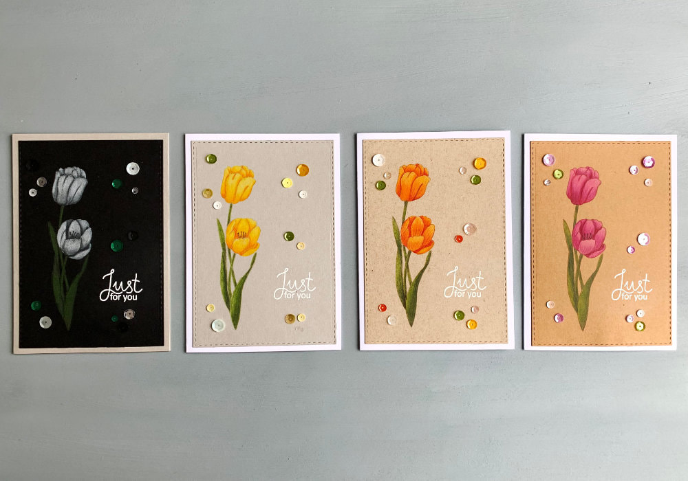 Handmade card with a yellow-orange tulip coloured with the Faber-Castell Polychromos pencils on a black cardstock, with a greeting heat embossed in white saying Just For You.