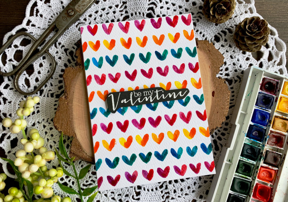 Make a very simple card for Valentine's day by painting a colourful background with hearts using watercolours.