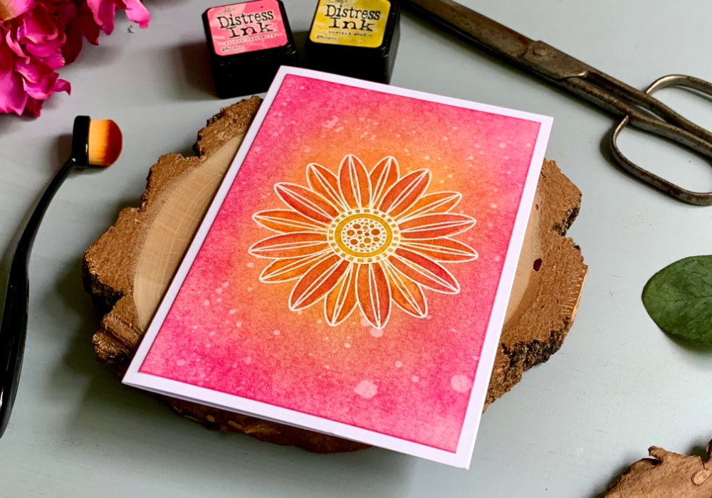 Handmade greeting card with a pink-yellow colour combination using the Tim Holtz Distress Mini Ink Pads Picked Raspberry and Mustard Seed. In the middle is a flower, stamped and heat embossed in white and watercoloured using the Distress inks.