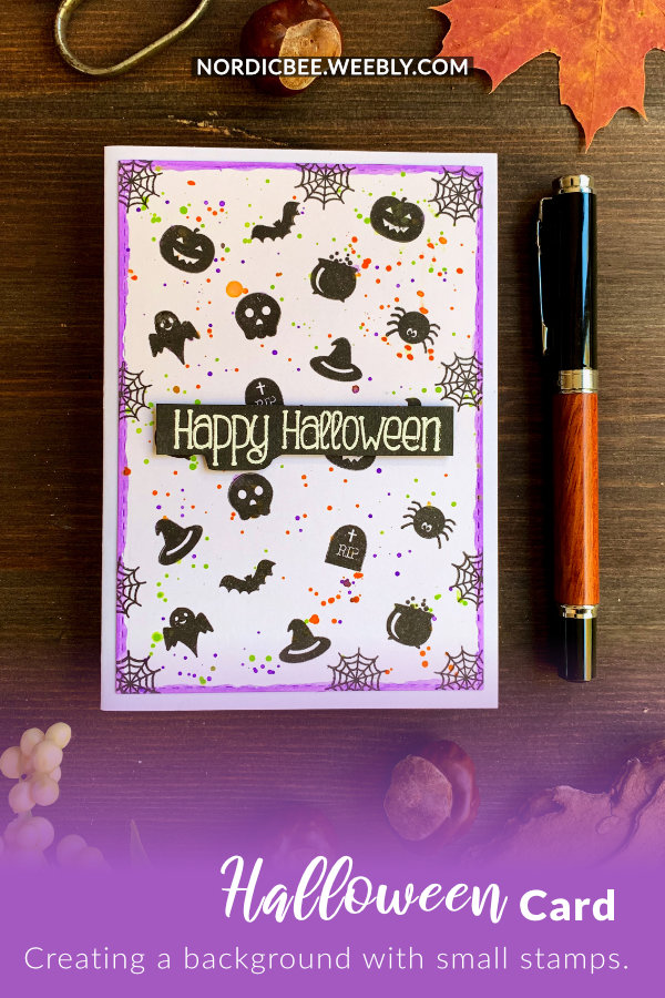Handmade Halloween card with a background stamped in black using small stamps with Halloween images - skull, spider, pumpkin, bat, etc., for colour added splatter in purple, green and orange and greeting embossed in white on a black banner that says Happy Halloween.