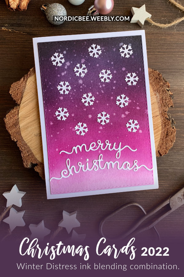 Handmade Christmas card with a pink and purple Distress ink blending combination idea using the inks Black Soot, Faded Jeans, Seedless Preserves, Picked Raspberry together with die-cut snowflakes and Merry Christmas greeting to create a simple snowy winter background.